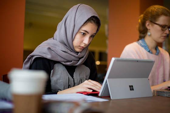 Photo of a Chatham University student writing on a tablet in Cafe Rachel